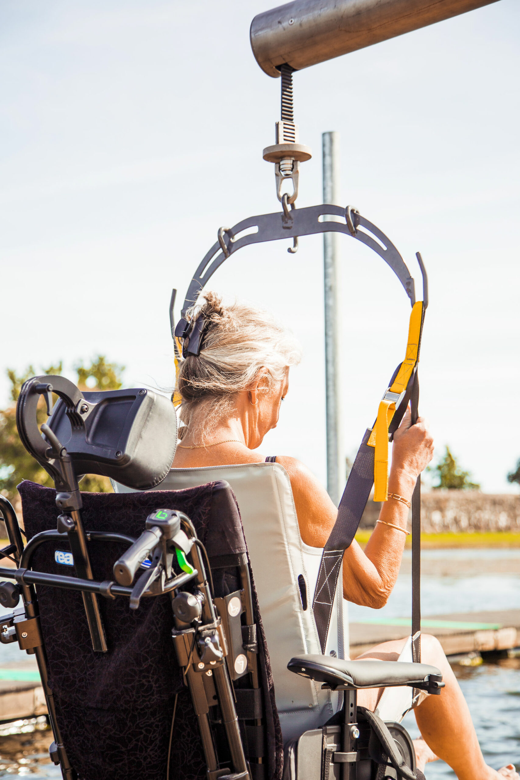 Kvinna i rullstol som är på väg att bli upplyft i en personlyft